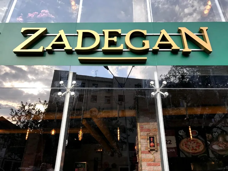 Zadegan — золотые объёмные буквы на стеклянном фасаде